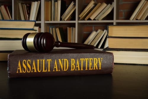 assault and battery law books on desk under gavel
